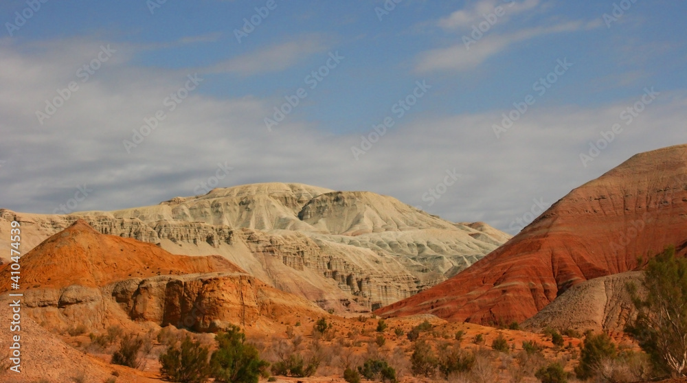 Aktau Mountains on sunrise. Beautiful landscape of colorful mountains in desert. Nature reserve Altyn Emel. Kazakhstan. Panorama with copy space