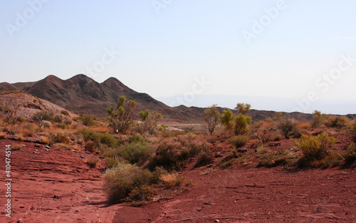 View of a Rock at Katutau red mountain range on a sunny blue sky day. Nature reserve Altyn Emel. Kazakhstan. Rock formations with interesting shapes. Frozen lava stones. photo