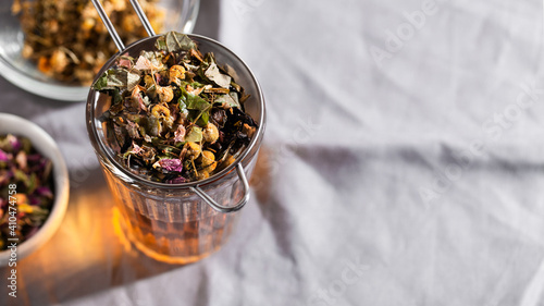 Herbal tea with chamomile, rose and mint on gray background with copy space. Home remedy concept