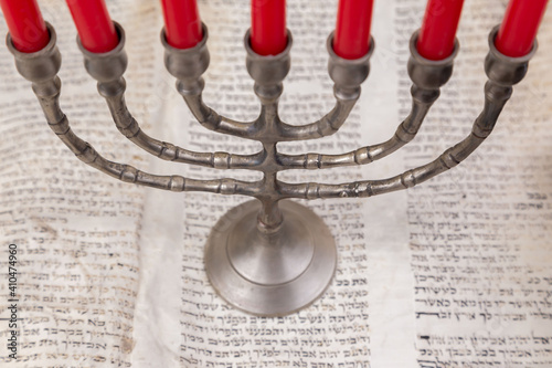 Old scrolls of the Bible and Menorah lie on a black background. Religion. Bible. Bible books. Christianity. God. Hebrew. Old chronicles. Israel. Jerusalem. Menorah. Seven candles.