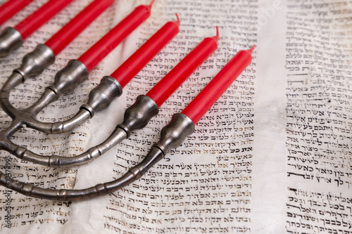 Old scrolls of the Bible and Menorah lie on a black background. Religion. Bible. Bible books. Christianity. God. Hebrew. Old chronicles. Israel. Jerusalem. Menorah. Seven candles. photo