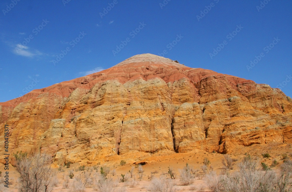 Fototapeta premium Aktau Mountains on sunrise. Beautiful landscape of colorful mountains in desert. Nature reserve Altyn Emel. Kazakhstan. Panorama with copy space