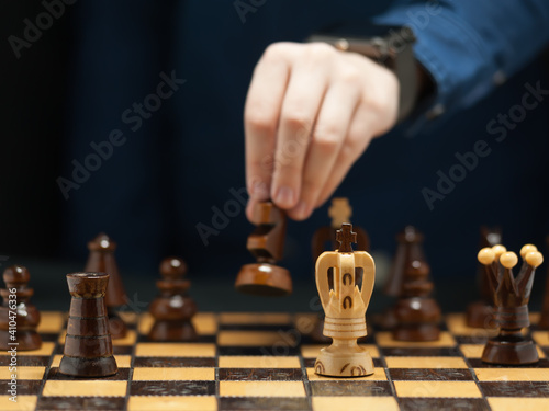 Fotografie The hand of the young grandmaster makes a move on horseback against the rival ki