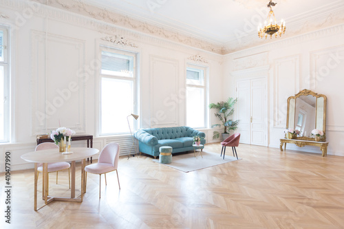 chic spacious light room in an old mansion in the classical style of the 19th century with a high ceiling decorated with stucco on white walls