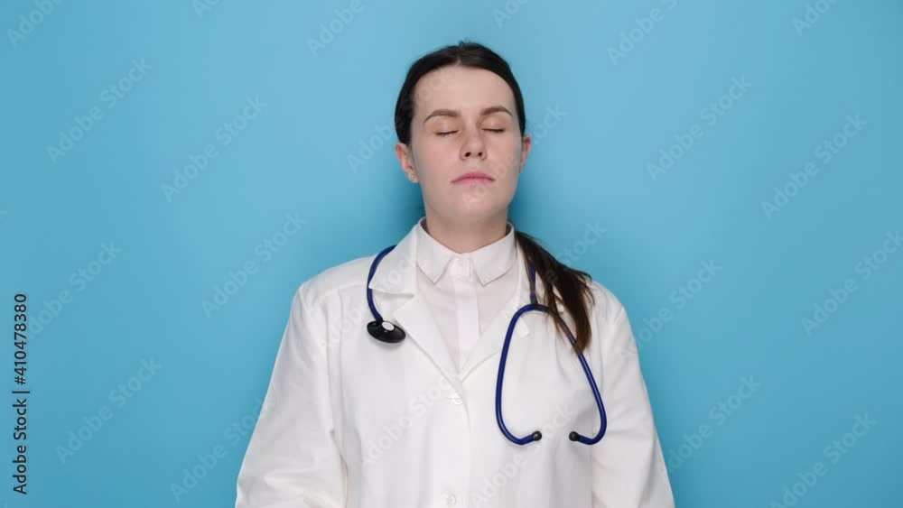 Professional woman doctor in latex protective gloves removing face mask, wears white uniform and stethoscope, isolated on blue background. Covid 19, healthcare workers and preventing virus concept