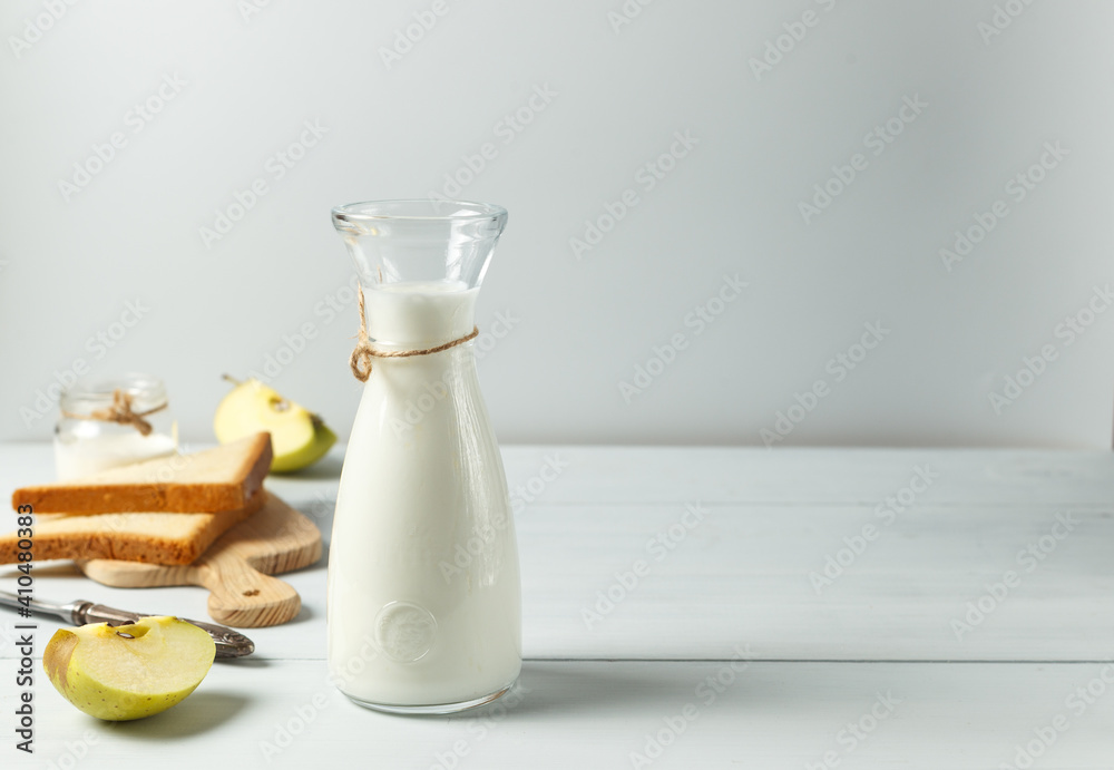 Fermented drink, kefir, natural yogurt in a glass carafe. On a light wooden background, with space Fermented drink, kefir, natural yogurt in a glass carafe. On a light wooden background, with space