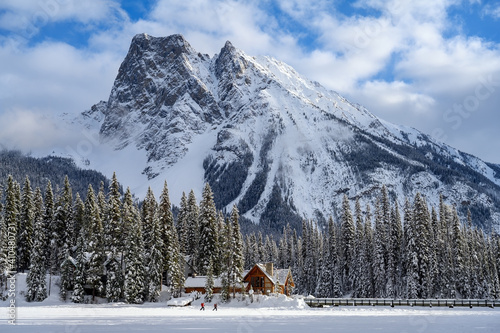 Backpackers or hikers hiking on the frozen Emerald Lake in the Yoho National Park, with Mount Burgess in the background in British Columbia, Canada photo