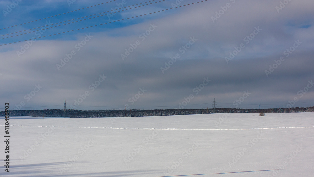 Suburbs of Grodno. Belarus. Winter landscape outside the city. Snowy field after heavy snowfall and forest in the distance.