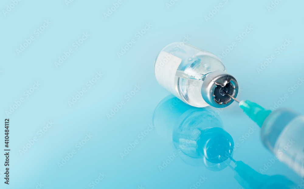 Medical background syringe for injection on a blue reflective medical table. Vaccination of the population against coronavirus Covid-19 . Place for text. Medical background syringe for injection on a blue reflective medical table. Vaccination of the population against coronavirus Covid-19 . Place for text.
