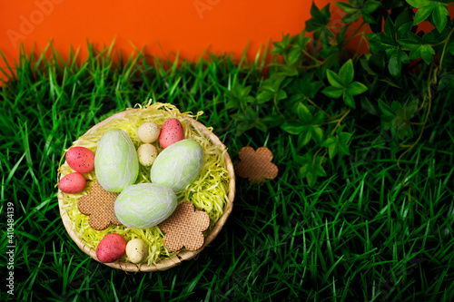  Chicken and quail Easter eggs in a nest on meadow grass