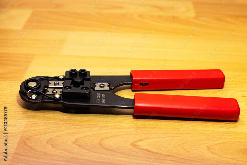Fotka „Crimper RJ45 and wire cutter on a wooden background. Twisting