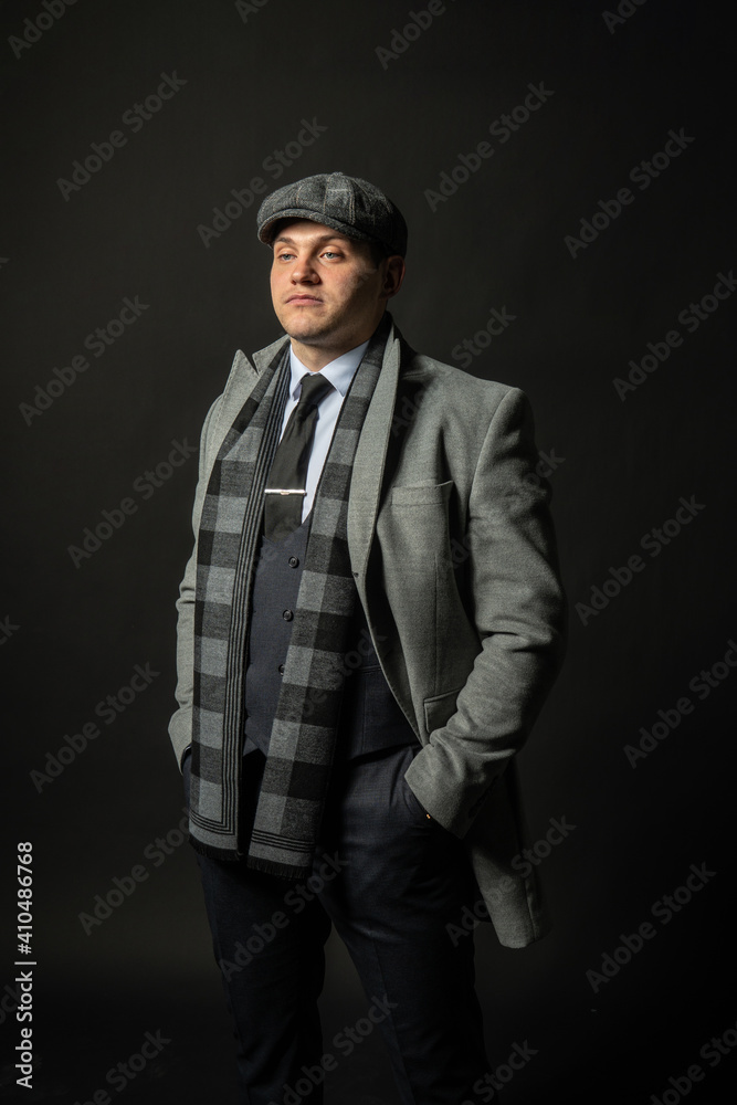 in a coat and a cap a scarf Young male three piece suit businessman model, casual standing. Handsome formal, successful smile background black bodybuilder in a coat and a cap a scarf Young male three piece suit businessman model, casual standing. Handsome formal, successful smile background black bodybuilder