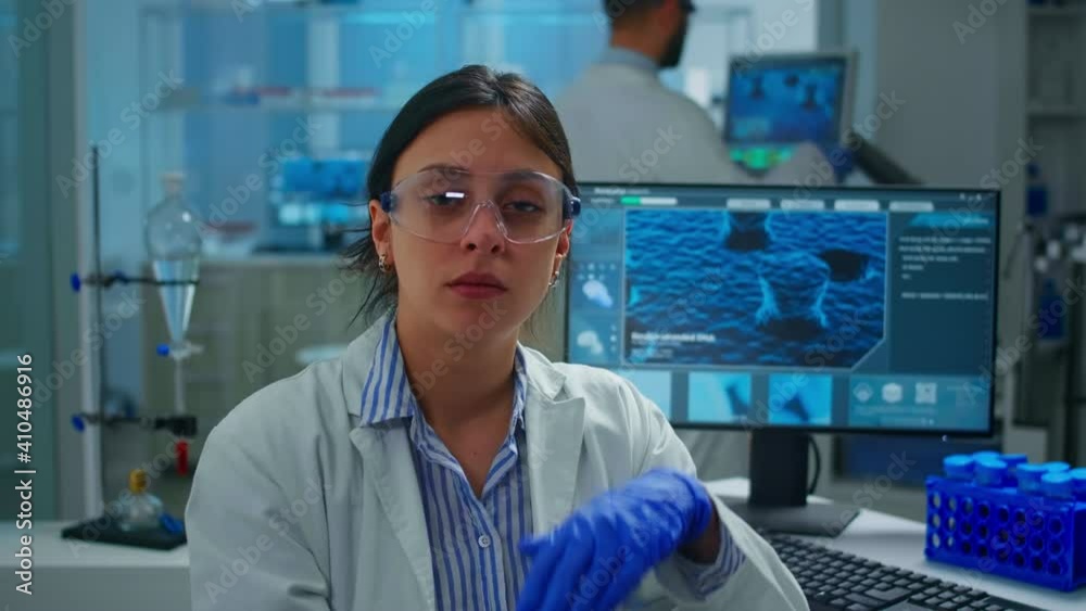 Outbreak chemist sitting in modern equipped lab looking tired at camera, yawning. Scientist examining virus evolution using high tech and chemistry tools for scientific research, vaccine development Outbreak chemist sitting in modern equipped lab looking tired at camera, yawning. Scientist examining virus evolution using high tech and chemistry tools for scientific research, vaccine development