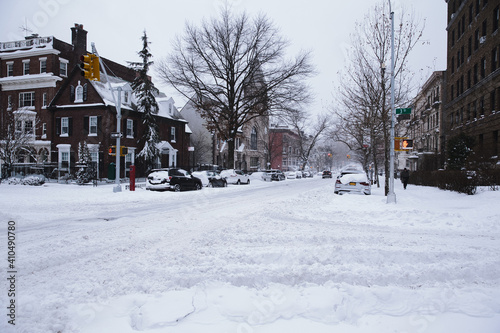 Winter scene with snow covered cars parked along streets in Brooklyn, NY