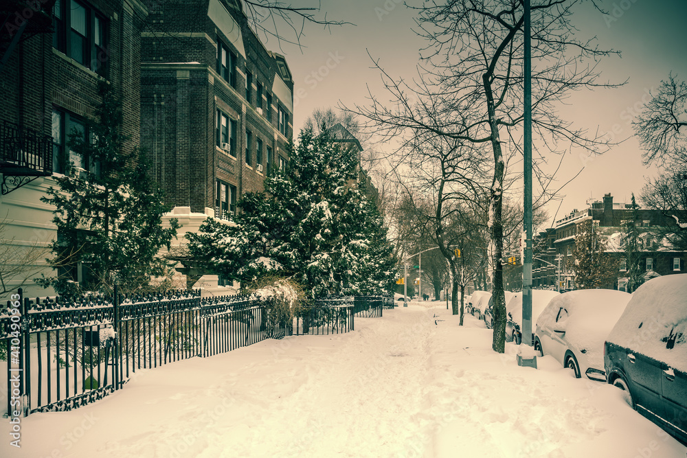 Winter scene with snow covered cars parked along streets in Brooklyn, NY. Brownstones in winter season