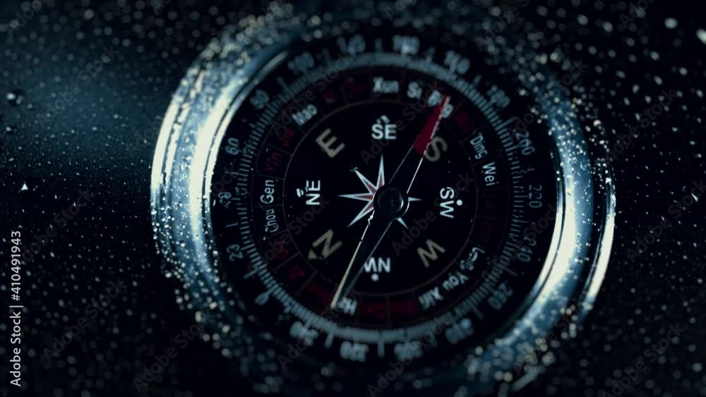 Compass in the rain drops on glass