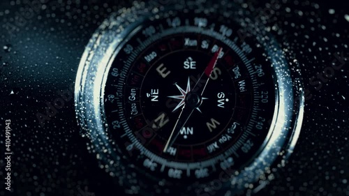 Compass in the rain drops on glass