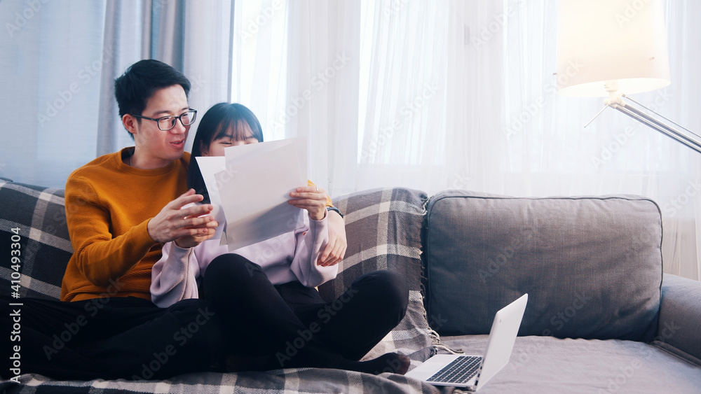 Happy young couple relaxing on the couch and looking at papers. High quality photo Happy young couple relaxing on the couch and looking at papers. High quality photo