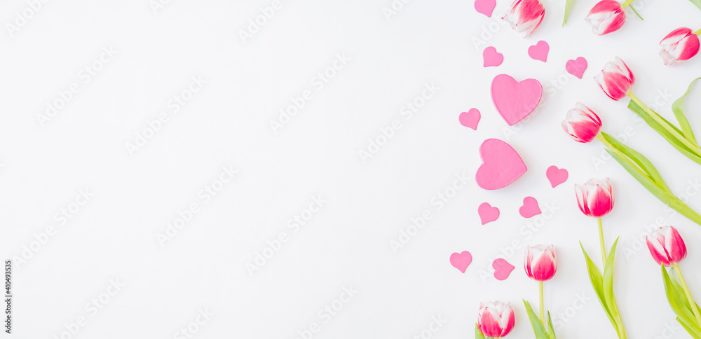 Flat lay valentines day frame with pink tulips and gift box on a white background