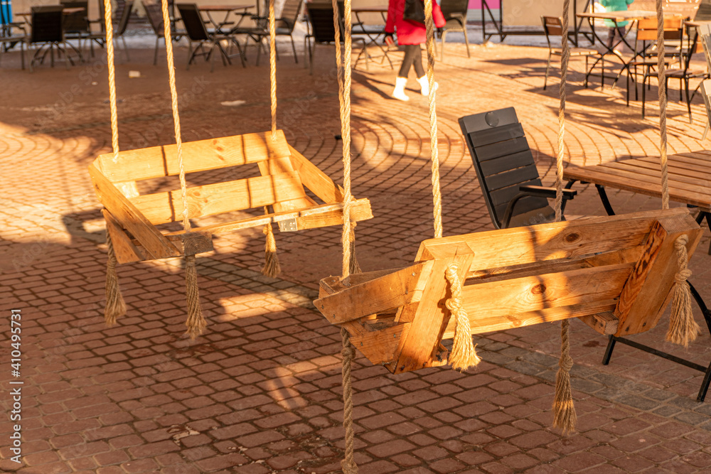 Wooden swing chair in the coffee shop for two person Wooden swing chair in the coffee shop for two person