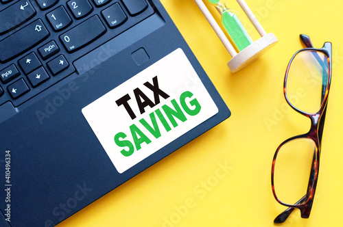 white paper with text TAX SAVING in male hands on a white background