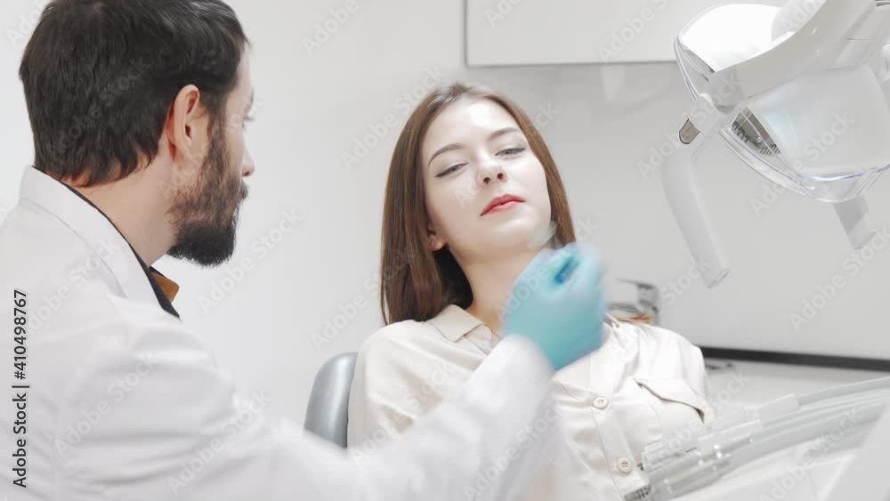 Lovely young woman having her teeth checked by dentist. Attractive female patient having dental examination at the clinic. Healthy teeth, occupation concept Lovely young woman having her teeth checked by dentist. Attractive female patient having dental examination at the clinic. Healthy teeth, occupation concept