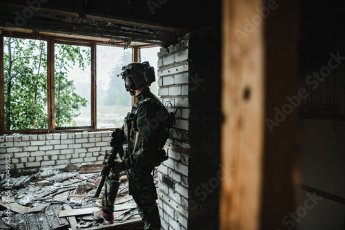 A thoughtful soldier  resting from a military operation while it is raining outside.