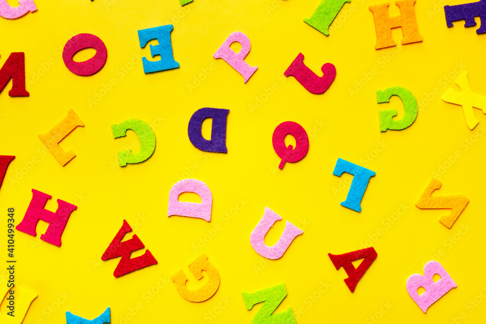 English alphabet letters on a yellow background pattern.