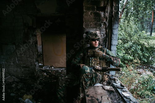 A thoughtful soldier, resting from a military operation while it is raining outside. © romankosolapov