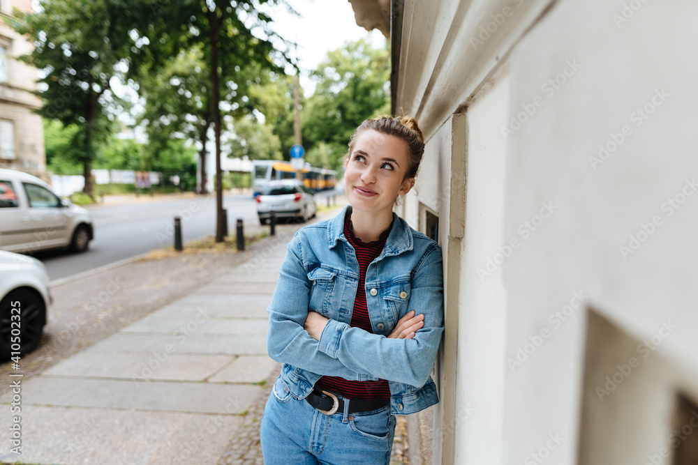 Relaxed woman in denim outfit standing watching