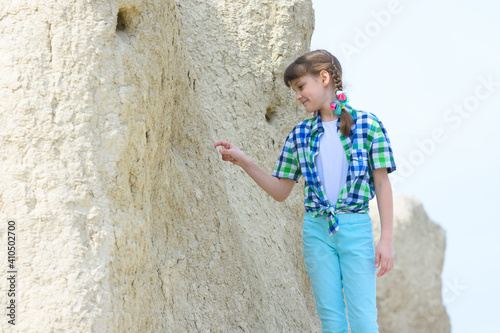 A ten-year-old girl picks a rock with her finger