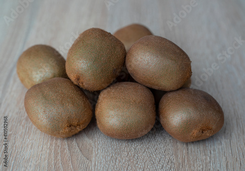 Group of ripe whole green kiwi fruit on a wooden table