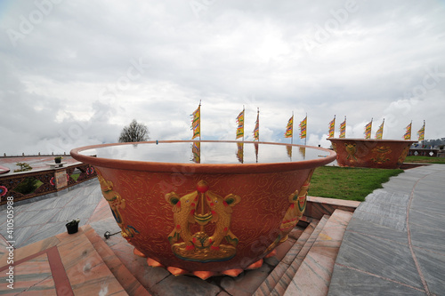 Containers with holy water in front of the Buddha statue in Tathagata Tsal (Buddha park) photo