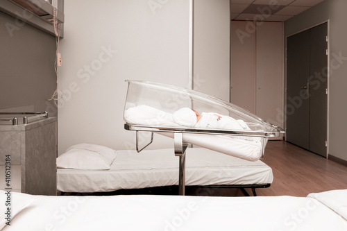 Newborn baby sleeping in the hospital bed photo