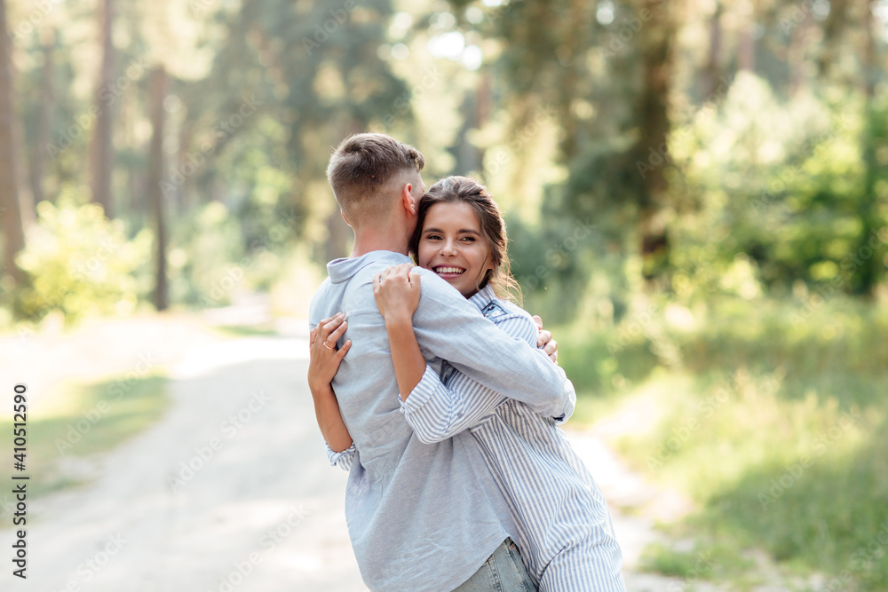 Cheerful young woman and man are hugging outdoors in summer park. Dating and romantic vacation. couple in love gently looking at each other on sunny day. Love and relationships between young people Cheerful young woman and man are hugging outdoors in summer park. Dating and romantic vacation. couple in love gently looking at each other on sunny day. Love and relationships between young people