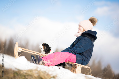 Little girl enjoying a sleigh ride. Child sledding. 