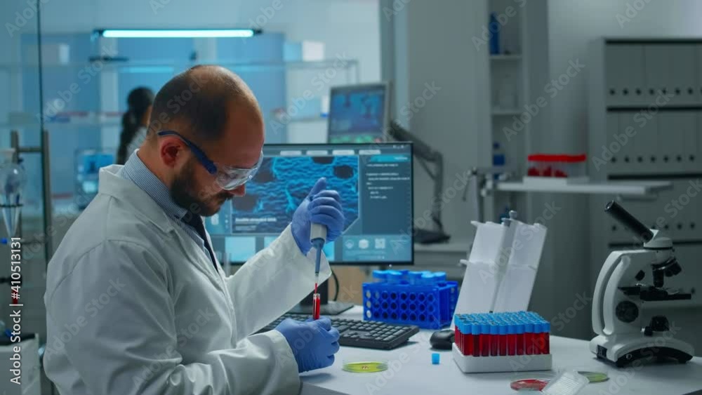 Scientist in medical laboratory examining drug discovery putting blood sample in petri dish with micropipette. Biochemist analysing virus evolution using high tech researching vaccine against covid19 Scientist in medical laboratory examining drug discovery putting blood sample in petri dish with micropipette. Biochemist analysing virus evolution using high tech researching vaccine against covid19