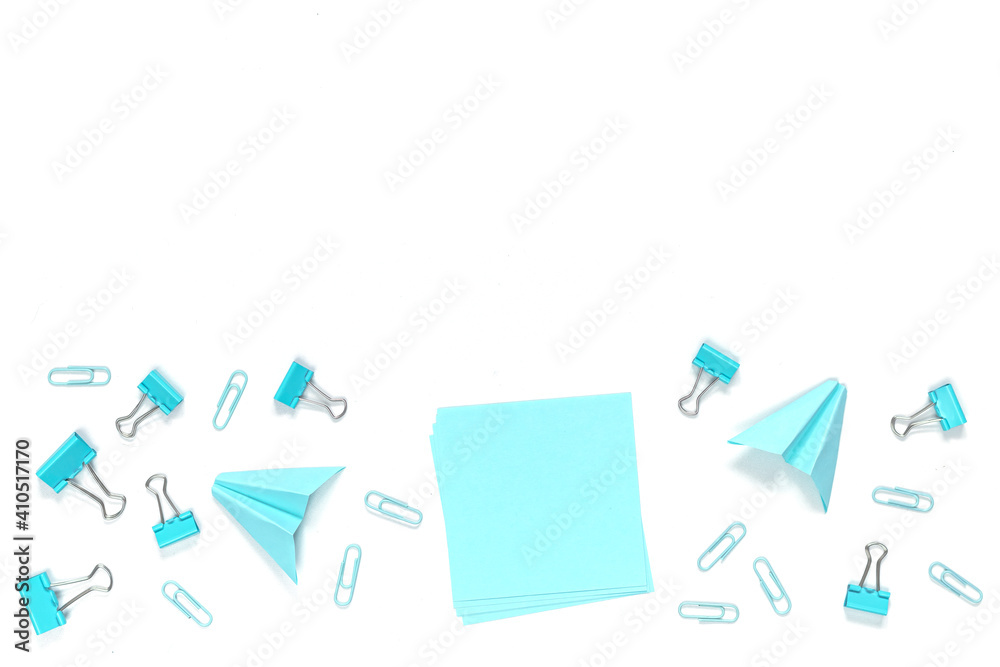 School and blue and white office supplies on white office table. Flat lay. Blue paper airplane and paper. Back to school concept. School and blue and white office supplies on white office table. Flat lay. Blue paper airplane and paper. Back to school concept.