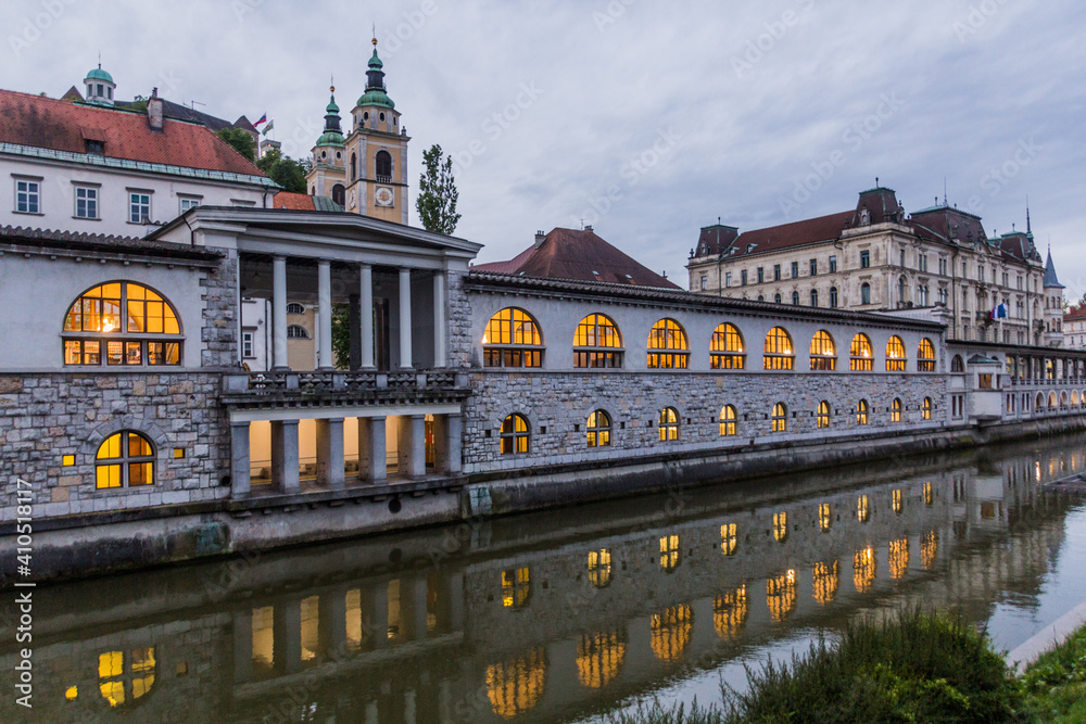 Plecnik arcade market building reflecting in Ljubljanica river in Ljubljana, Slovenia