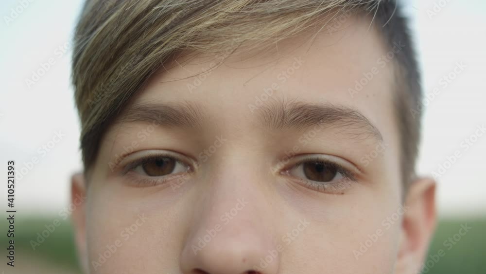 portrait of a serious boy looking at the camera and smiling, close-up of eyes portrait of a serious boy looking at the camera and smiling, close-up of eyes