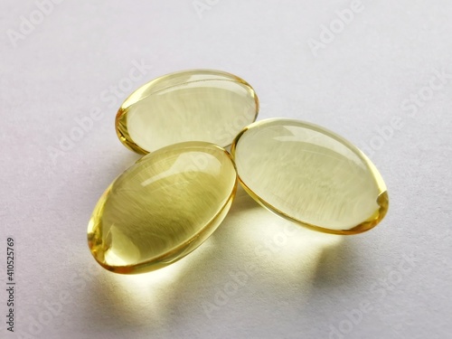 Three transparent yellow pills on a white background