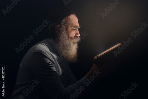 Foto A senior man standing in dark smoky background light ray from above
