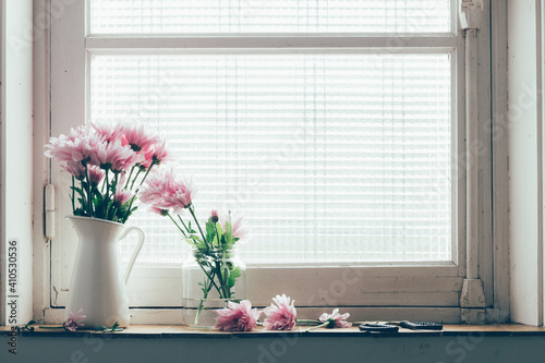 Pastel pink flowers on a vintage window sill.