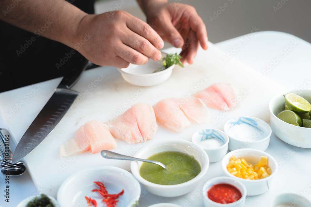 Closeup de manos de un chef preparando una receta de pescado