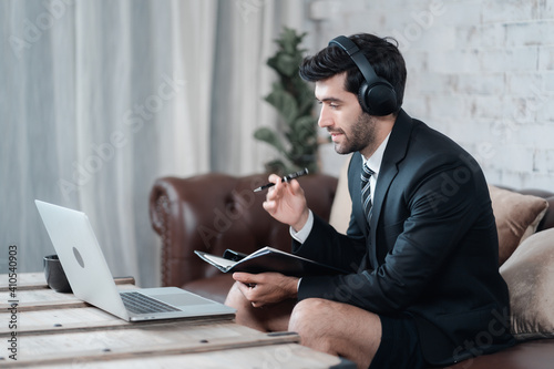 Caucasian businessman have online conference at home with laptop while dress half suit and shorts. New normal concept of work from home, self quarantine during Covid-19 pandemic