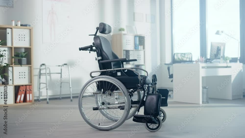 Hospital Physical Therapy Room with Modern High-Tech Electric Wheelchair Standing in the Middle. Physiotherapy Rehabilitation Center Concept with Empty Chair Meaning Successfully Cured Patients. Hospital Physical Therapy Room with Modern High-Tech Electric Wheelchair Standing in the Middle. Physiotherapy Rehabilitation Center Concept with Empty Chair Meaning Successfully Cured Patients.