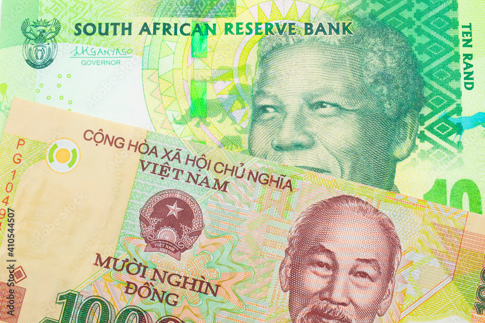 Fototapeta premium A macro image of a shiny, green 10 rand bill from South Africa paired up with a colorful, plastic ten thousand dong note from Vietnam. Shot close up in macro.