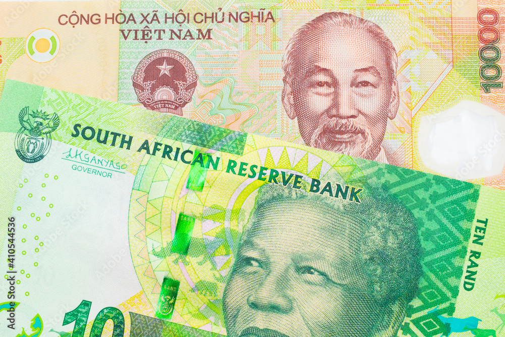 A macro image of a shiny, green 10 rand bill from South Africa paired up with a colorful, plastic ten thousand dong note from Vietnam.  Shot close up in macro.