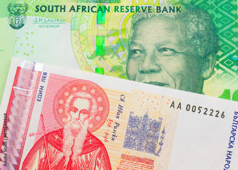Fototapeta premium A macro image of a shiny, green 10 rand bill from South Africa paired up with a red and white one lev bank note from Bulgaria. Shot close up in macro.