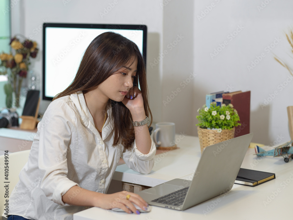 Female office worker work from home with laptop and computer in home office room Female office worker work from home with laptop and computer in home office room